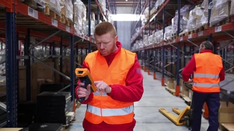 Warehouse worker scanning and managing inventory with barcode scanner Stock Footage 312856314