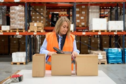 Warehouse worker scanning packages with barcode scanner Stock Photos