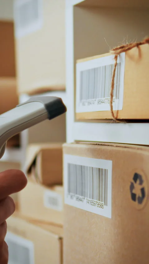 Warehouse worker scans barcode to manage inventory efficiently during busy h Stock Footage 331738019