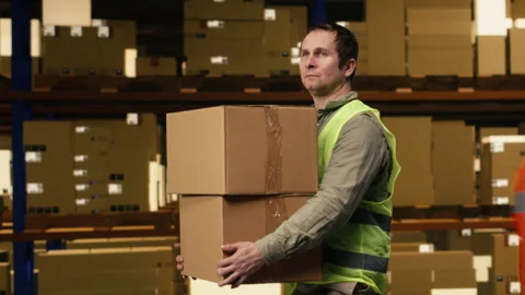 Warehouse worker stacking cargo pallets in distribution hub facility Stock Footage 332911395