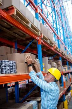 Warehouse worker taking package in the shelf in warehouse Stockfoto's