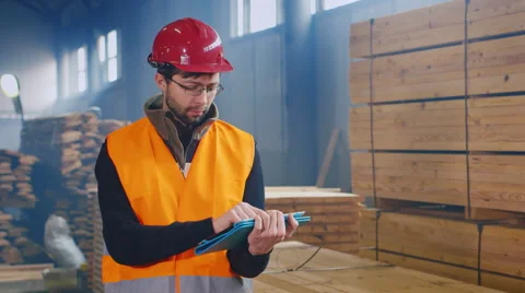 Warehouse worker uses a tablet. Writes data on the availability of building Stock Footage 61793959