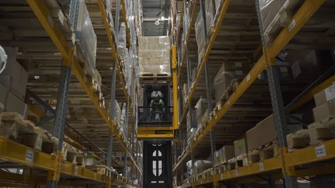 Warehouse worker using car and forklift, loading delivering cardboard goods for Stock Footage 127674933