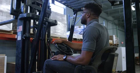 Warehouse worker using a forklift to lift shipment pellet in warehouse Stock Footage 116365489