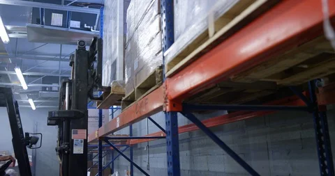 Warehouse worker using a forklift to lift a shipment pellet in warehouse Stock Footage 116365965