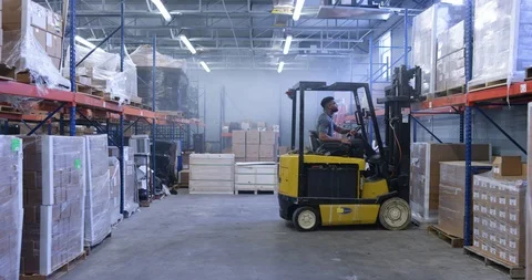 Warehouse worker using a forklift to lift a shipment pellet in warehouse Stock Footage 116368468