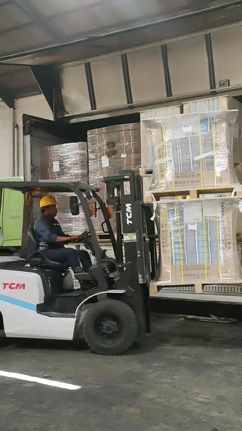 Warehouse Worker Using a Forklift to Load Goods onto a Truck Stock Footage 303369988