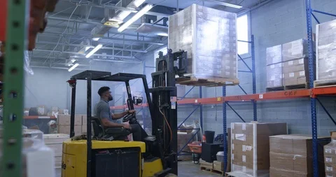 Warehouse worker using a forklift to place shipment pellet in warehouse Stock Footage 116365818