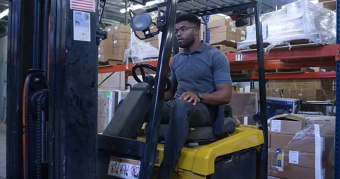 Warehouse worker using a forklift in warehouse Stock Footage 116365220