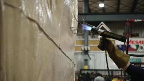 Warehouse worker using heat gun to weld tarpaulin, slow motion Stock Footage 225816973