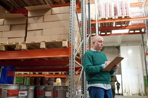 Warehouse worker using list to control transportation Stock Photos