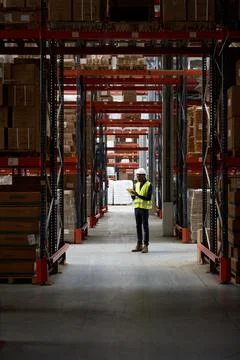 Warehouse worker using tablet and managing inventory in logistics center Stock Photos