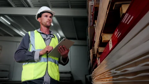 Warehouse Worker Using Tablet for Inventory Check in Storage Facility Vídeo Stock 345012732