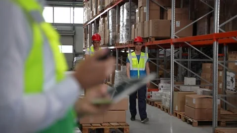 Warehouse worker using walkie-talkie and tablet Stock Footage 161947958