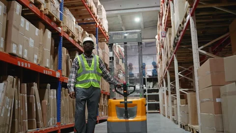 Warehouse Worker Walking with Forklift in Storage Aisle Stock Footage 294264589