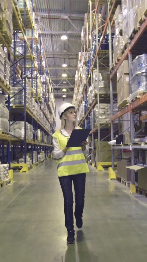 Warehouse worker walks through rows of warehouse Stock Footage 224830924