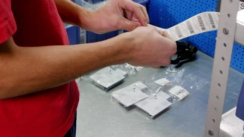 Warehouse worker in work uniform puts stickers on goods Stock Footage 238767288