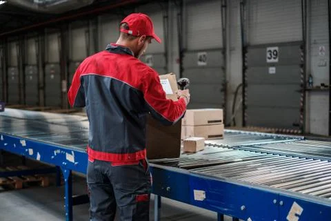 Warehouse worker working on a conveyor line Foto stock