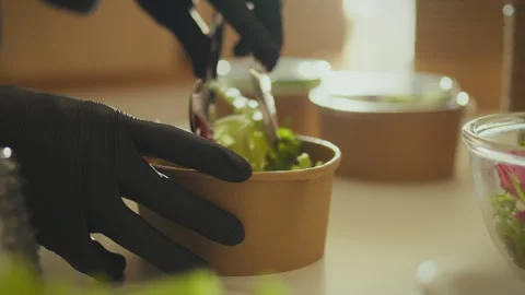 A warehouse worker, young and energetic, packs takeout orders in an industri Stock Footage 266156761