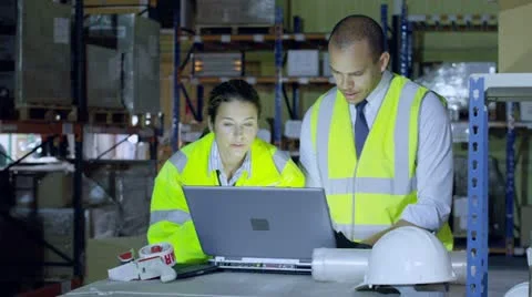 Warehouse workers are discussing their business and looking at a laptop computer Vidéo 13696067