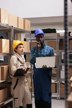 Warehouse workers checking factory goods supply and monitoring dispatching Stock Photos