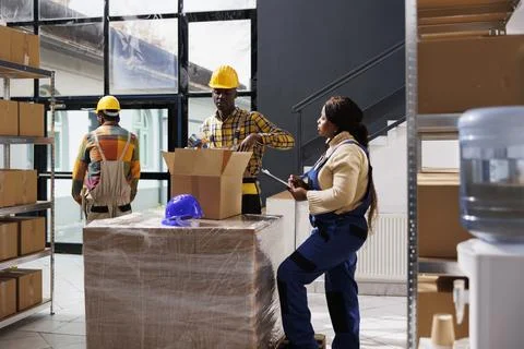 Warehouse workers checking order in parcel and sealing box Stockfoto's