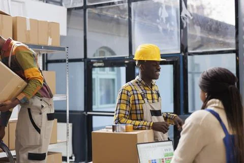 Warehouse workers checking pick ticket, preparing parcel for shipping Foto stock