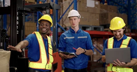 Warehouse workers of different ethnicities discuss shipping logistics while Stock Footage 307006209