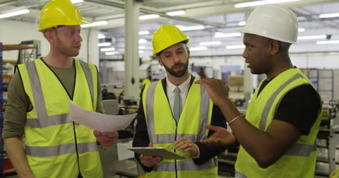 Warehouse workers discuss the logistics of their business on a digital tablet. Stock Footage 48714022