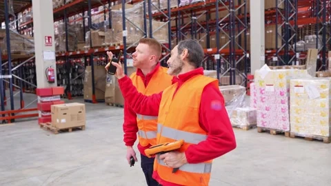 Warehouse workers discussing logistics and inventory management Stock Footage 312856305