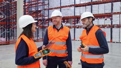 Warehouse workers discussing logistics with handheld devices Stock Footage 312856370