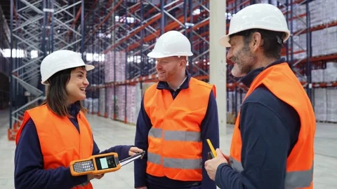Warehouse workers discussing logistics with handheld devices Stock Footage 312856383
