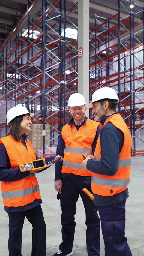 Warehouse workers discussing logistics with handheld devices Stock Footage 312856501
