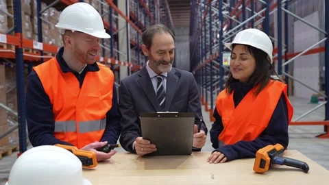 Warehouse workers discussing logistics with manager Stock Footage 312856435