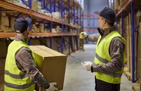 Warehouse workers doing inventory stocktaking with clipboard, boxes and Stock Photos