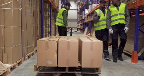 Warehouse workers moving boxes on pallet truck shelves for shipping logistics Stock Footage 327177462