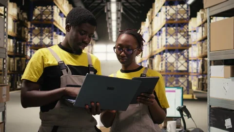 Warehouse workers overseeing parcels tracking info on gadgets 스톡 동영상 315541586