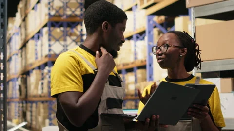 Warehouse workers overseeing parcels tracking info on gadgets Stock Footage 315706445