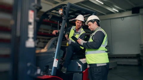 Warehouse Workers Reviewing Logistics Data Beside Forklift. Vídeos de archivo 345012661