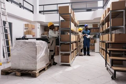 Warehouse workers scanning parcels barcodes and making inventory Stock Photos