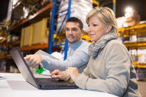 Warehouse workers studying data from software Stock Photos