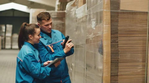 Warehouse workers, using a QR code reader, scan the barcode of the goods. Stock Footage 220686387