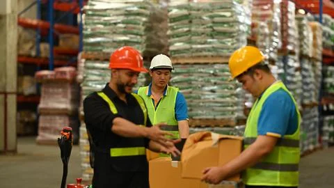 Warehouse workers working in the retail warehouse full of shelves with goods Stockfoto's