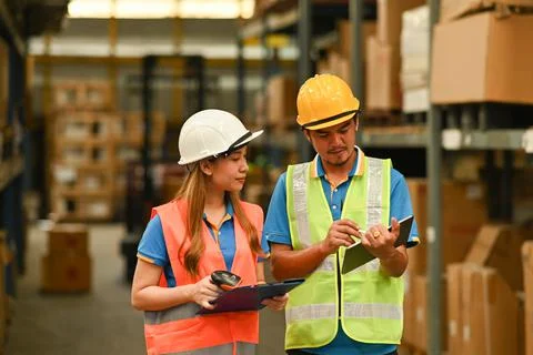 Warehouse workers working in the retail warehouse full of shelves with goods 스톡 사진