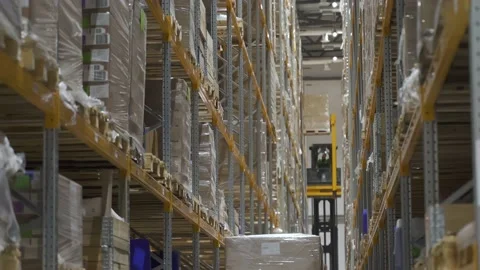 Warehouses large logistics structure with cardboard boxes. worker using machine Stock Footage 149389003