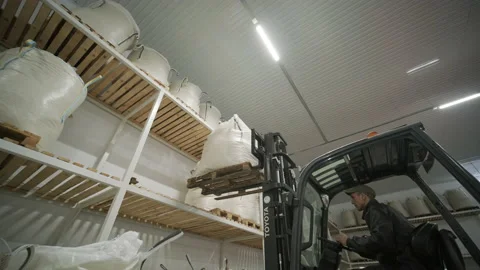 Warehousing. Forklift driver stacking big bag of raw material in warehouse. Stock Footage 146032287