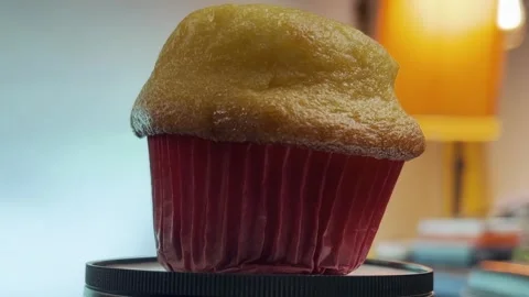 Warm and inviting close-up of a delicious golden muffin in red wrapper Stock Footage 296142053