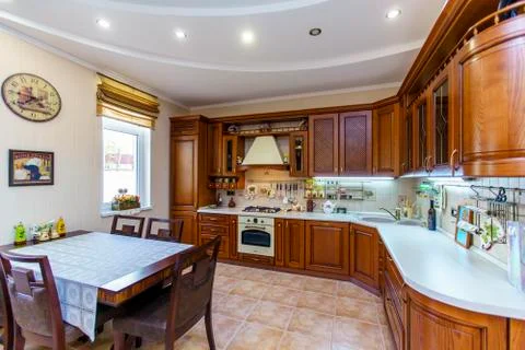 Warm and inviting kitchen with large kitchen island, cherrywood cabinets, gol Stock Photos