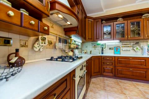 Warm and inviting kitchen with large kitchen island, cherrywood cabinets, gol Stock Photos