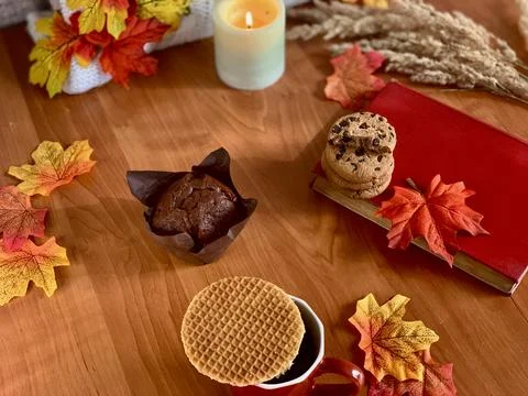 A warm and inviting table displays a muffin, cookies, and a waffle. Bright Foto stock